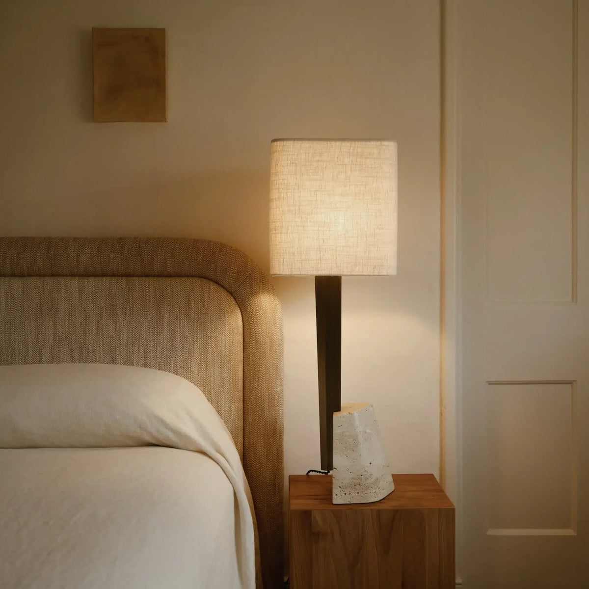 Roc Table light showcasing its sculptural antique bronze structure, natural linen shade and refined material palette