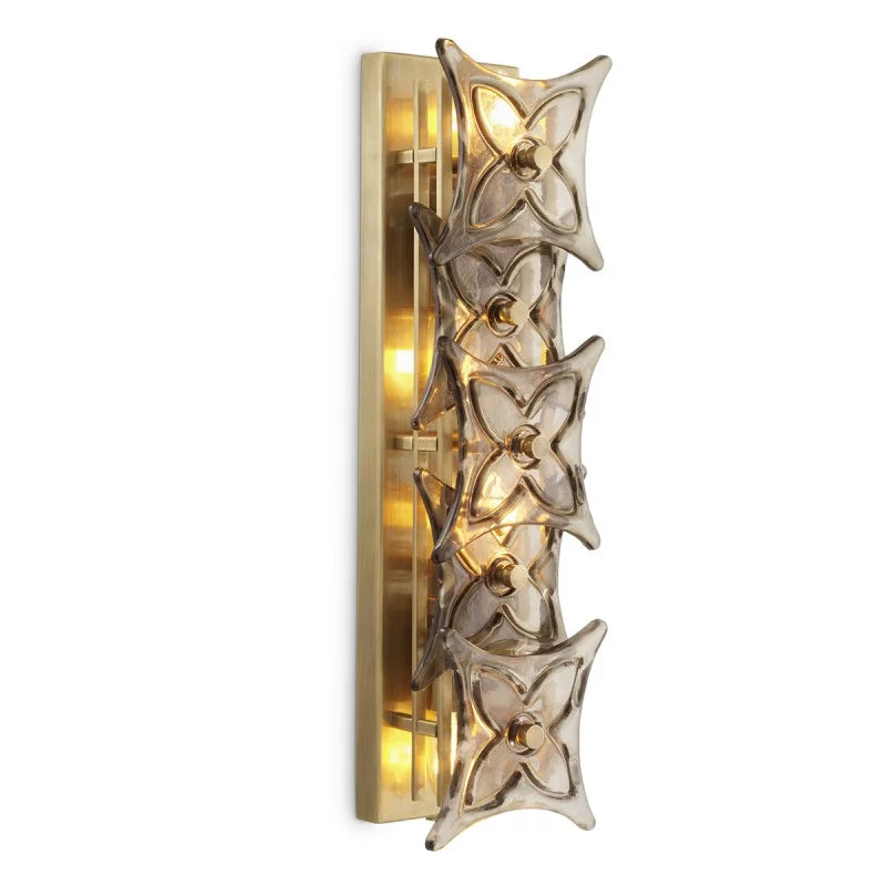 Elegant Silvaris wall lamp with jewel-like smoke glass detailing and warm vintage brass structure